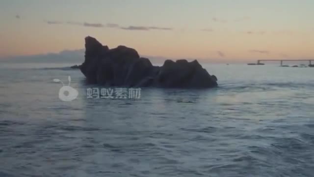 海滩旁的雄伟的岩石男人在海滩上凝视大海风景-第3张图